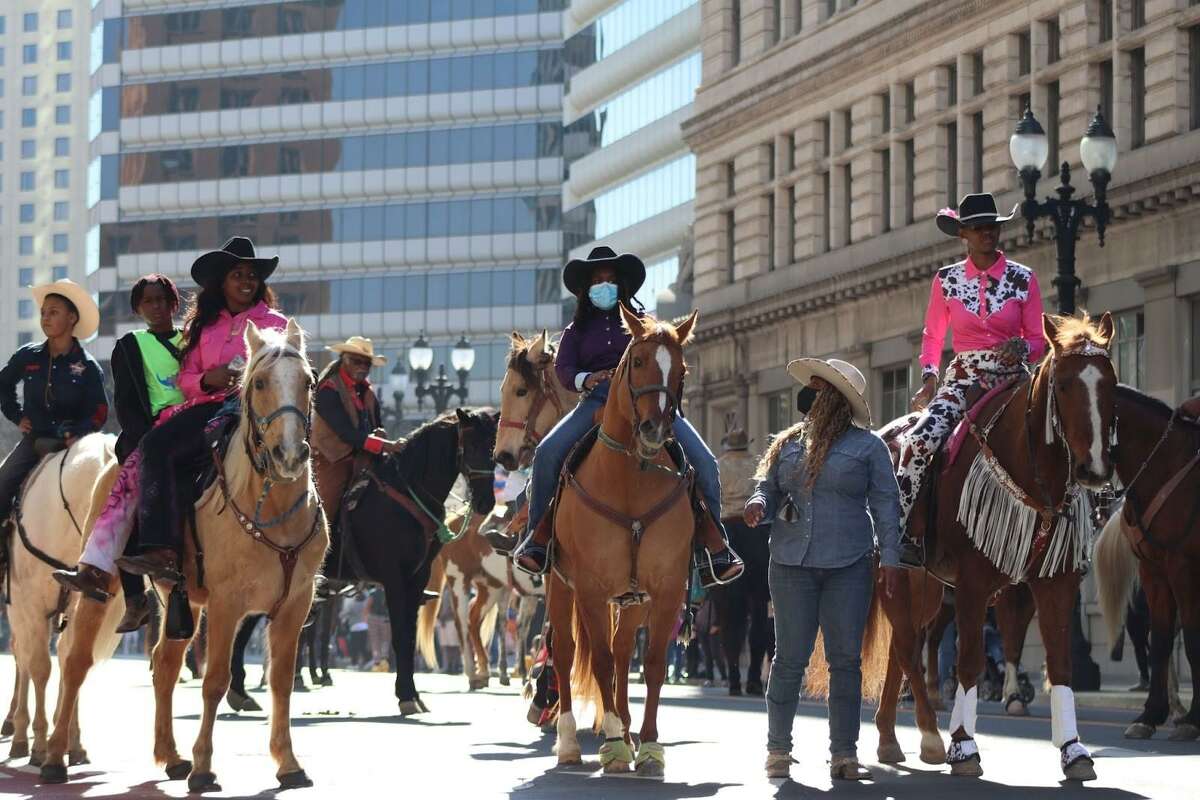 Members of the Northern California Black Cowboys & Cowgirls Association ride down Broadway in the Black Joy Parade. One rider was subsequently struck by a car.