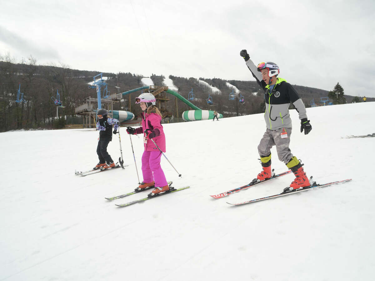Paralympian alpine skier Tyler Carter descends the slope at Camelback Ski Resort in Tannersville with Ava McEntirer, 12, of West Chester, left, and Madison Hahs, 10, of West Grove, Chester County.
