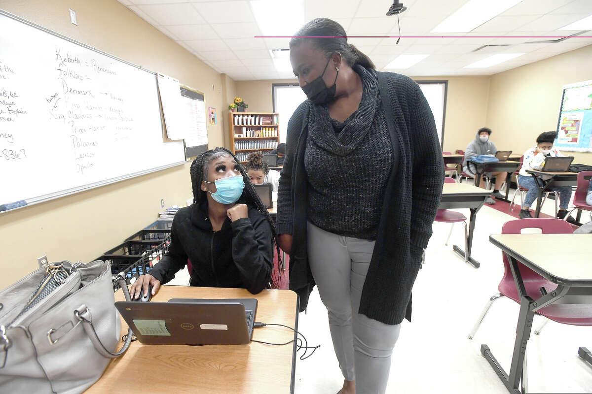 Stacia McKinney talks with Arrenzi Robinson as she circulates the room, checking on her English students' progress, at the Paul Brown Center, which is undergoing a program redesign, some of which has already been implemented. Photo made Thursday, February 24, 2022 Kim Brent/The Enterprise