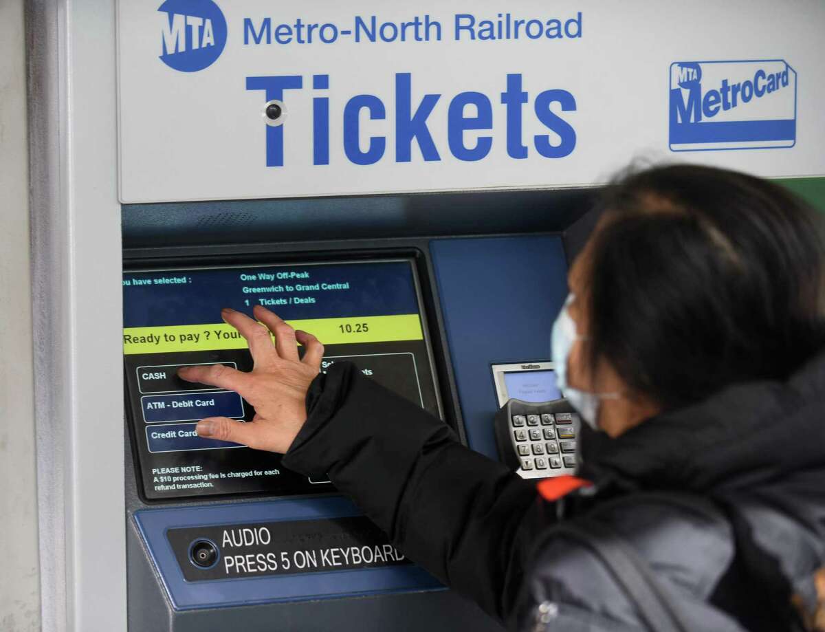 A commuter pays $10.25 for a Metro-North single trip off-peak ticket to Grand Central Terminal from the Greenwich Train Station in Greenwich, Conn. Monday, Feb. 28, 2022.