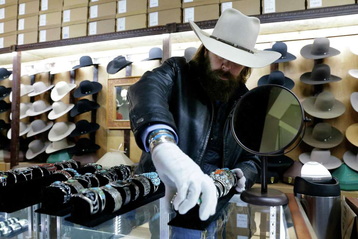 Employee Chance Miller sets out turquoise jewelry on counters at the Sombrero Brands vendor booth at the NRG Arena for this year’s Houston Livestock Show & Rodeo.