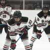 New Canaan's Doster Crowell (23), Owen Briggs (26) and Michael Rayher (28) focus on a facoff during a boys ice hockey game against Fairfield at the Darien Ice House on Monday, Feb. 14, 2022.