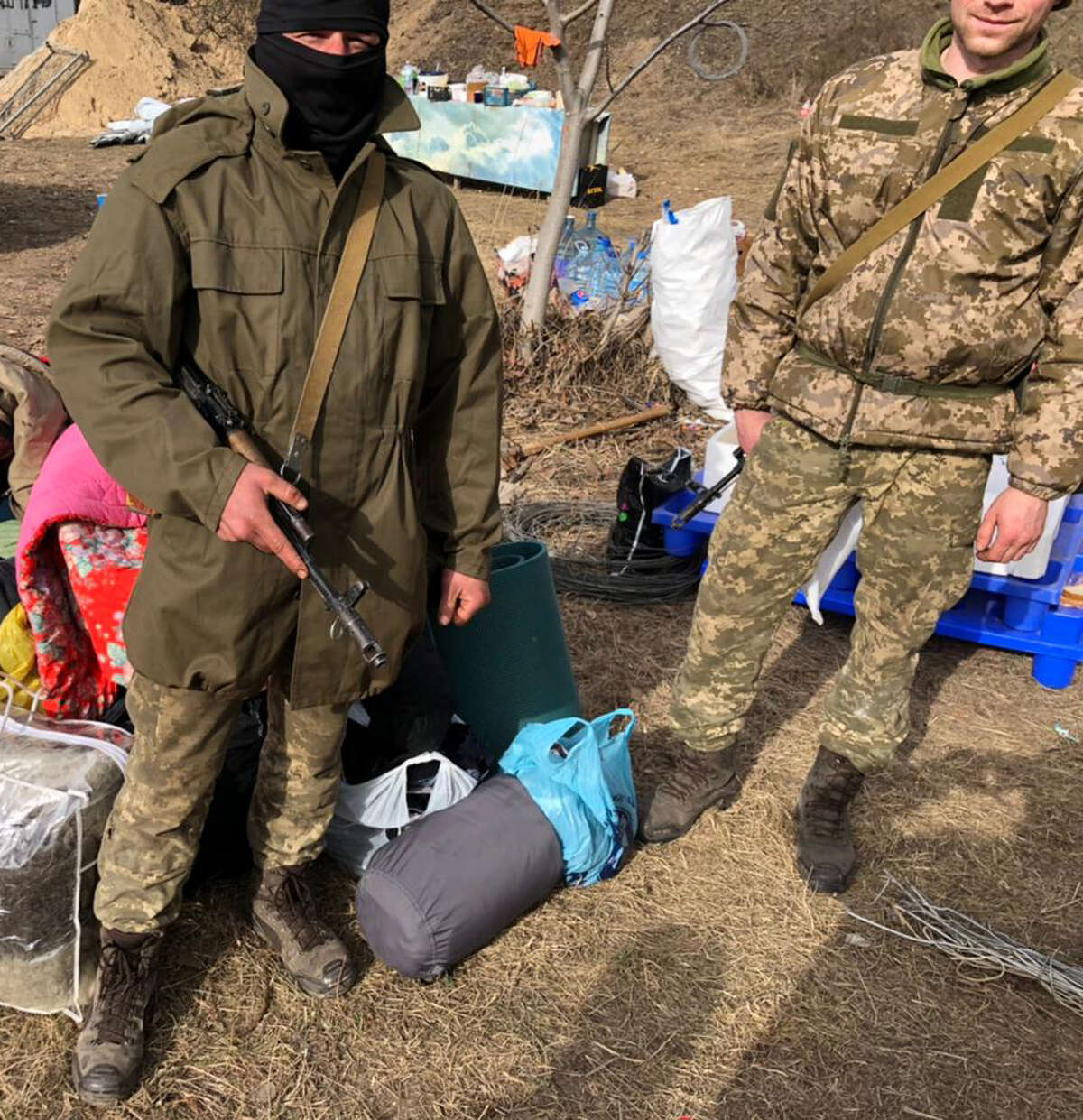 Volunteer fighters for Ukraine's Territorial Defence Forces pose with supplies donated by community members in the days after Russia's invasion of Ukraine on Feb. 24, 2022.