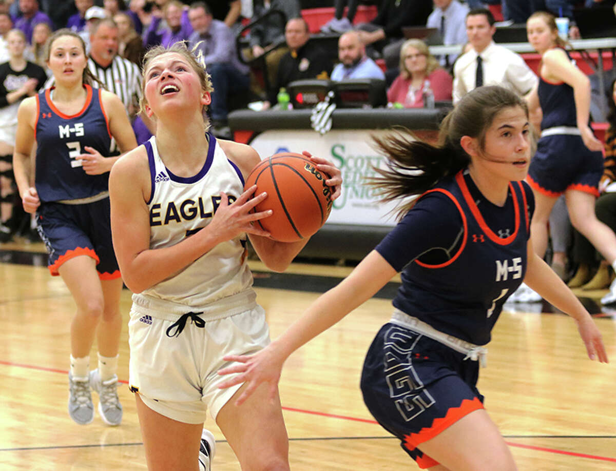 CM's Kelbie Zupan takes the ball to the basket while Mahomet-Seymour's Durbin Thomas (right) contests the play in the first half  Monday night in the Highland Class 3A Super-Sectional.