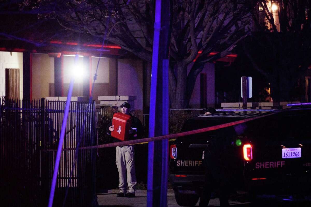 Police officers investigate the scene of a shooting at the Church in Sacramento on Monday. Police have said a father killed himself after shooting and killing his family, including three children, at the church.