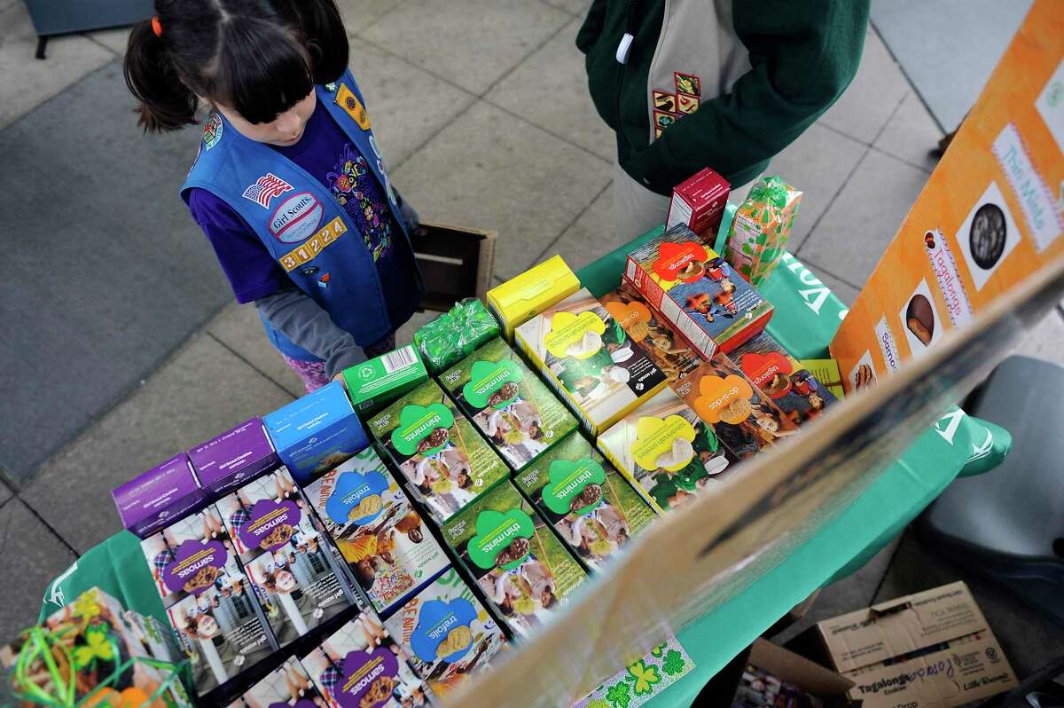 Girl Scout Kelly Aissa,7, of San Francisco restocks the table display of cookies for sale at Safeway on 7th Ave. and Cabrillo St. in San Francisco in a 2013 photo.