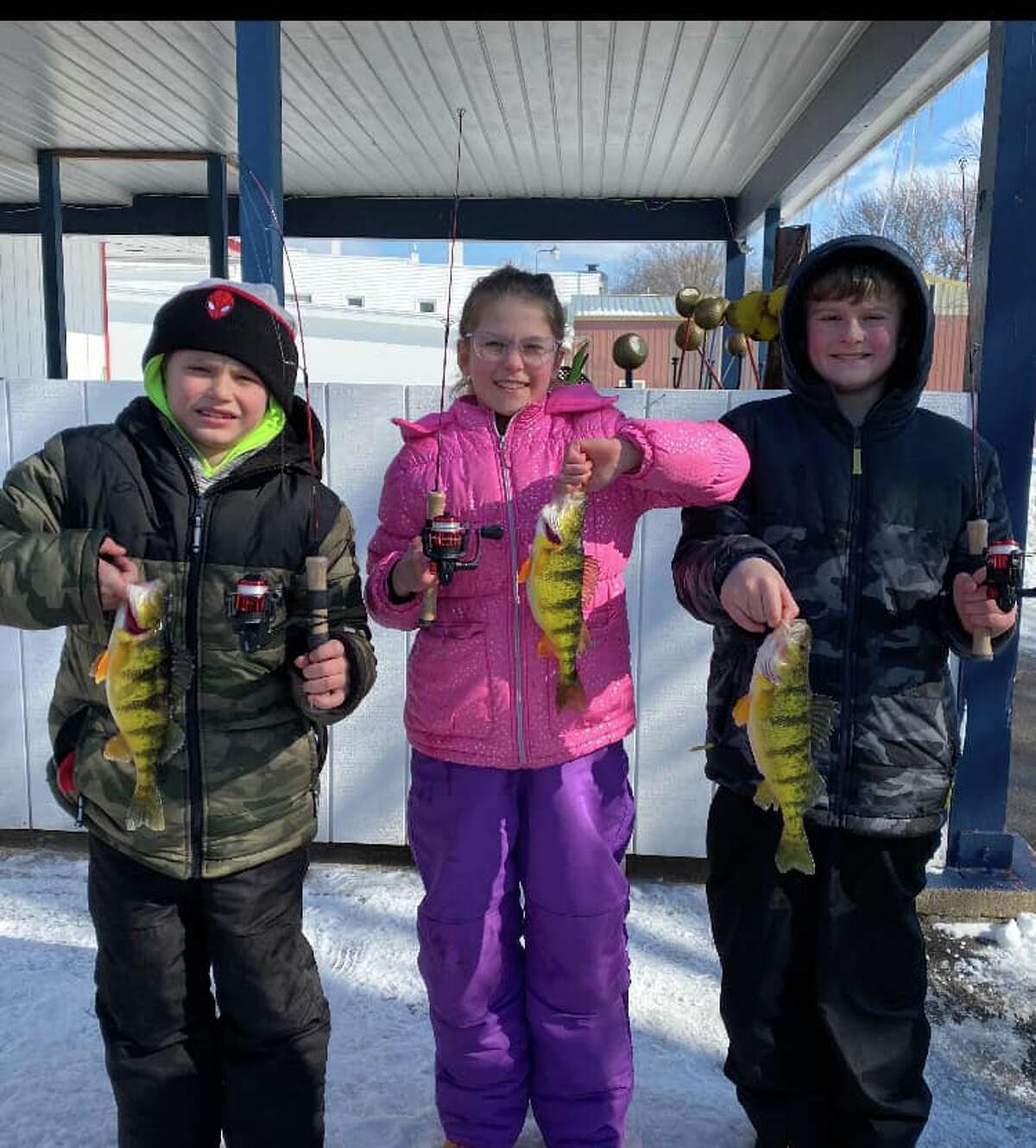 Remington, Hazel and Jason Sedelmaier show off their perch caught during the Fun Fish event hosted by the Manistee County Sport Fishing Association event over the weekend. 