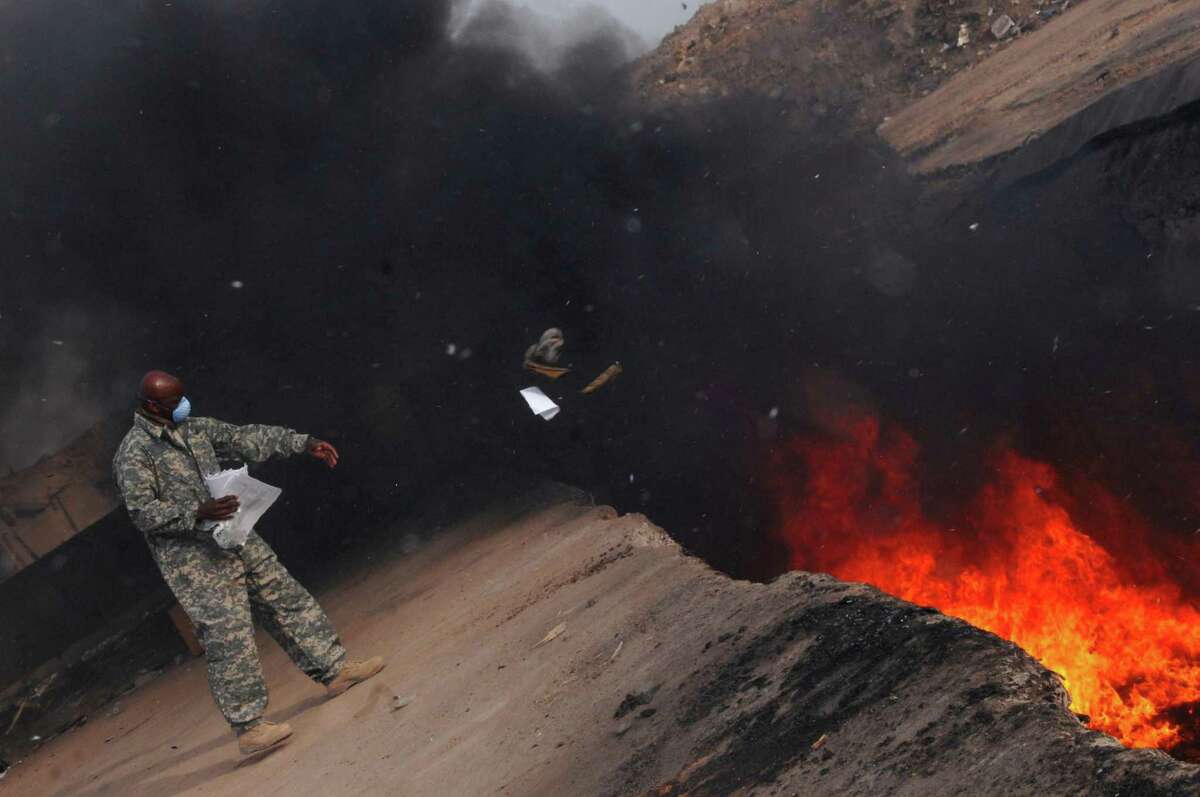 U.S. Air Force Master Sgt. Darryl Sterling tosses items into a burn pit at Balad Air Base, Iraq, in 2008. Exposure to hazardous materials is linked to dozens of health conditions among veterans, and yet the government has been slow to acknowledge the links.