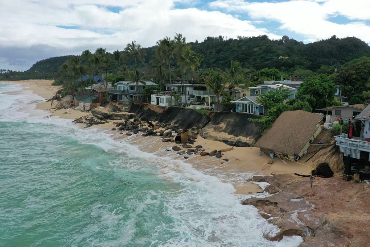 A home on the North Shore of Oahu collapses on the beach.