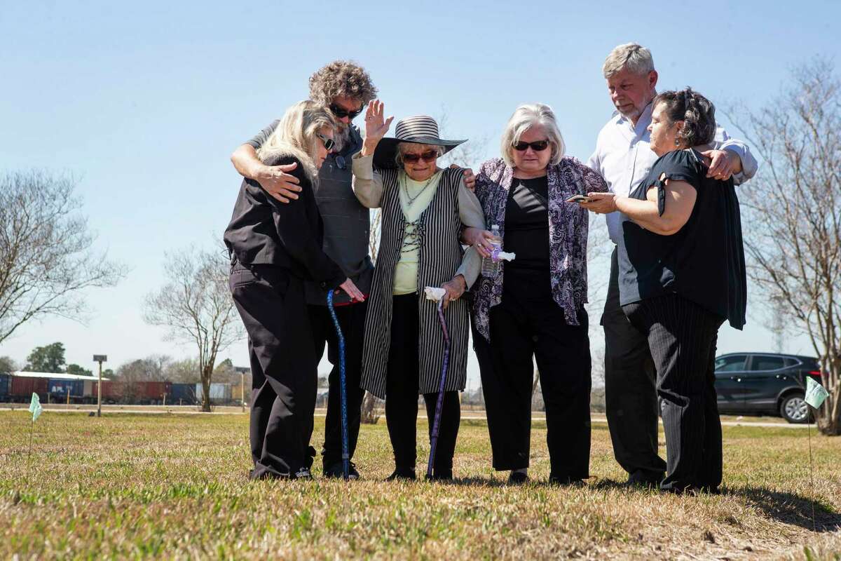 Debbie Brooks, from left, Christopher Casasanta, Donna Casasanta, Cheryl Clouse, Les Linn and Tess Welch embrace and pray at the gravesite of their loved ones, Harold Dean Clouse and his wife, Tina Gail Linn, in the Harris County Cemetery #2 Tuesday, March 1, 2022 in Houston.
