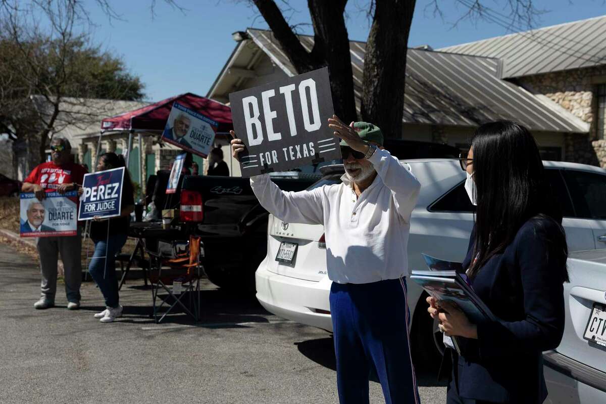 Joe Garcia holds a handmade Beto sign while standing next to Beca Moyer DeFelice, who is running for state representative. The pair were among a dozen people holding signs for various political candidates outside of Lion’s Field as voters walk by to cast their ballots in the primary election.