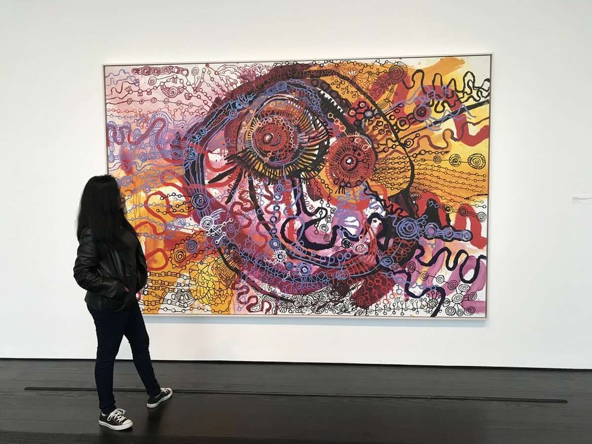A woman looks at a painting exhibited at the Menil Collection.