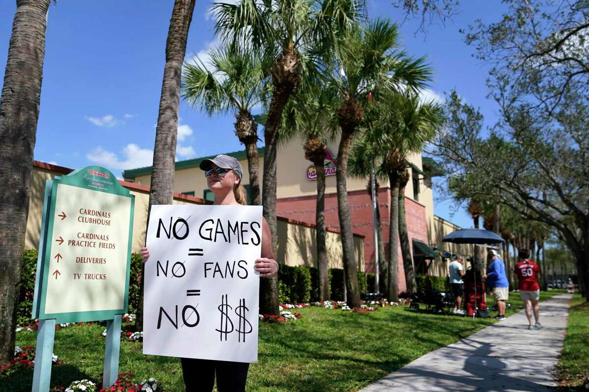 Detroit Tigers fan Genna Perugini of Melbourne, Fla. holds a sign outside of Roger Dean Stadium where negotiations between Major League Baseball and the players union continue in an attempt to reach an agreement to salvage March 31 openers and a 162-game season, Monday, Feb. 28, 2022, in Jupiter, Fla. (AP Photo/Lynne Sladky)