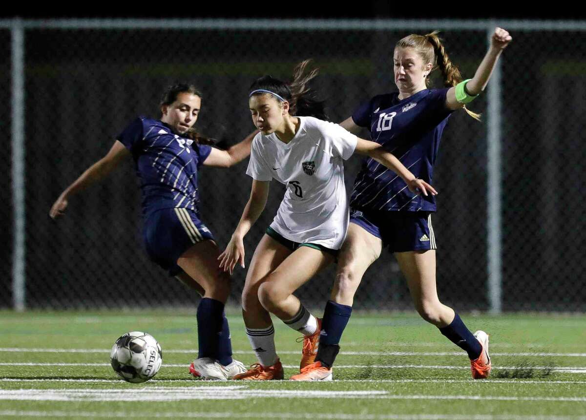 Kingwood Park's Sienna Morales (6) battles for the ball against and Lake Creek's Alayna Misenheimer (14) and Taylor Hampton (18) in the first period of a District 20-5A high school soccer match at Lake Creek High School, Tuesday, March 1, 2022, in Montgomery.