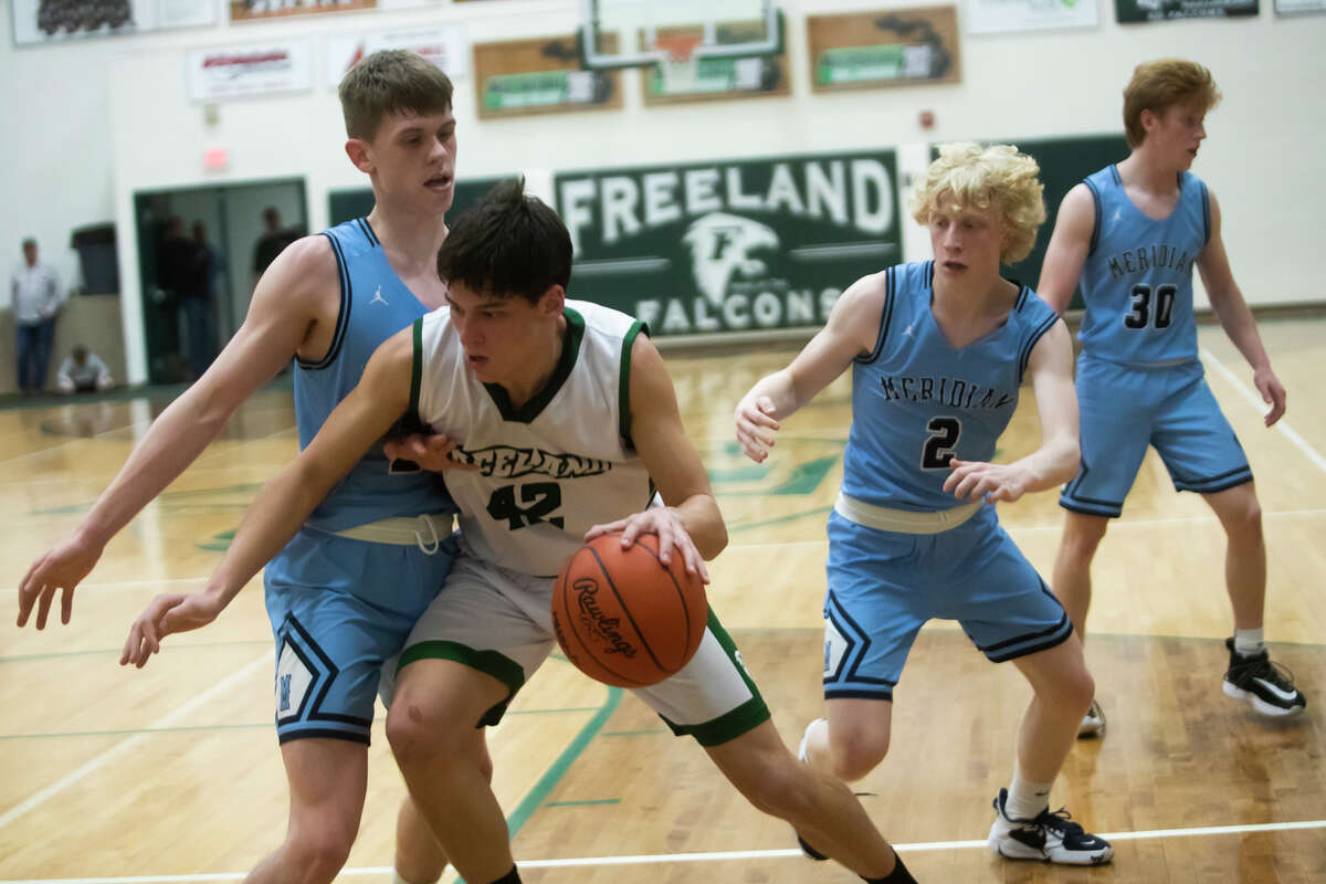 Freeland's Alex Duley dribbles towards the basket while Meridian's Sawyer Moloy guards him during their game Tuesday, March 1, 2022 at Freeland High School.