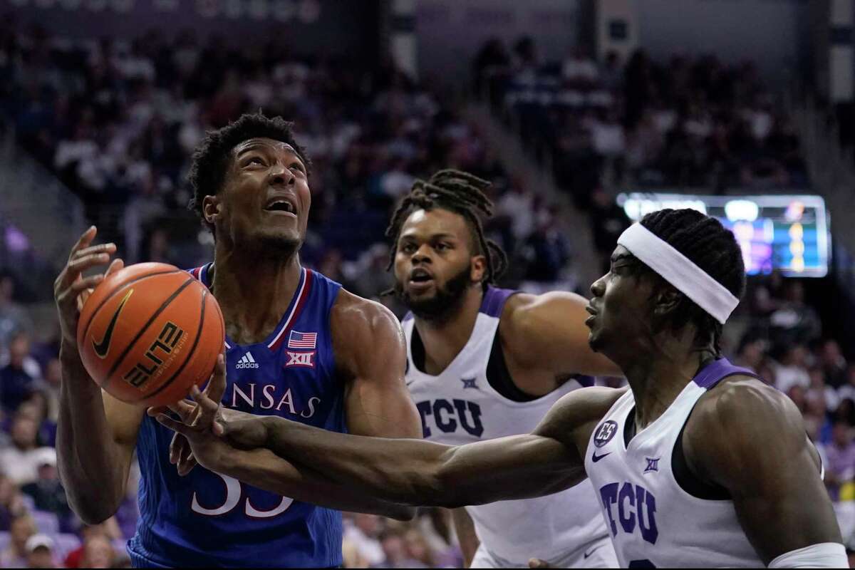 Kansas forward David McCormack (33) is fouled positioning for a shot any TCU forward Emanuel Miller, right, as Eddie Lampkin, rear, looks on in the first half of an NCAA college basketball game in Fort Worth, Texas, Tuesday, March 1, 2022.