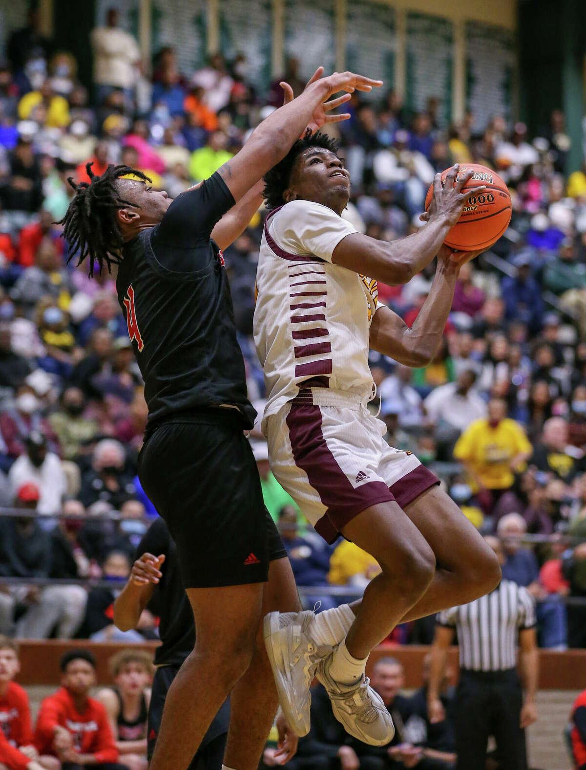 Beaumont United forward Terrance Arceneaux (23) squeezes past a Goose Creek defender for a basket Tuesday night at East Chambers High School in Winnie, TX. Photo taken March 1, 2022 by Jarrod Brown