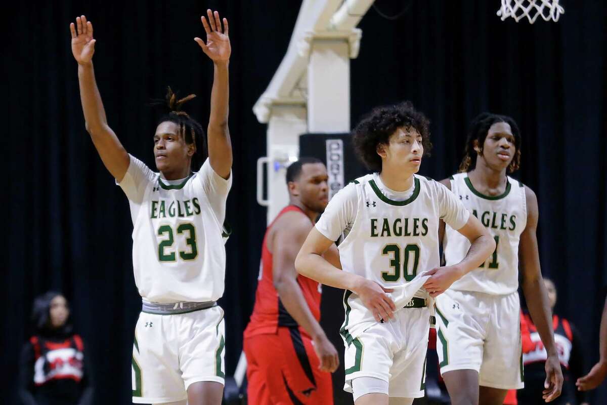Cypress Falls’ Jesaiah McWright (23) raises his arms as he leaves the court with Jacob Duran (30) and Joseph Tugler after their win over Westfield in the UIL Region II-6A boys basketball regional quarterfinals game held at the Berry Center Tuesday, Mar. 1, 2022 in Cypress, TX.