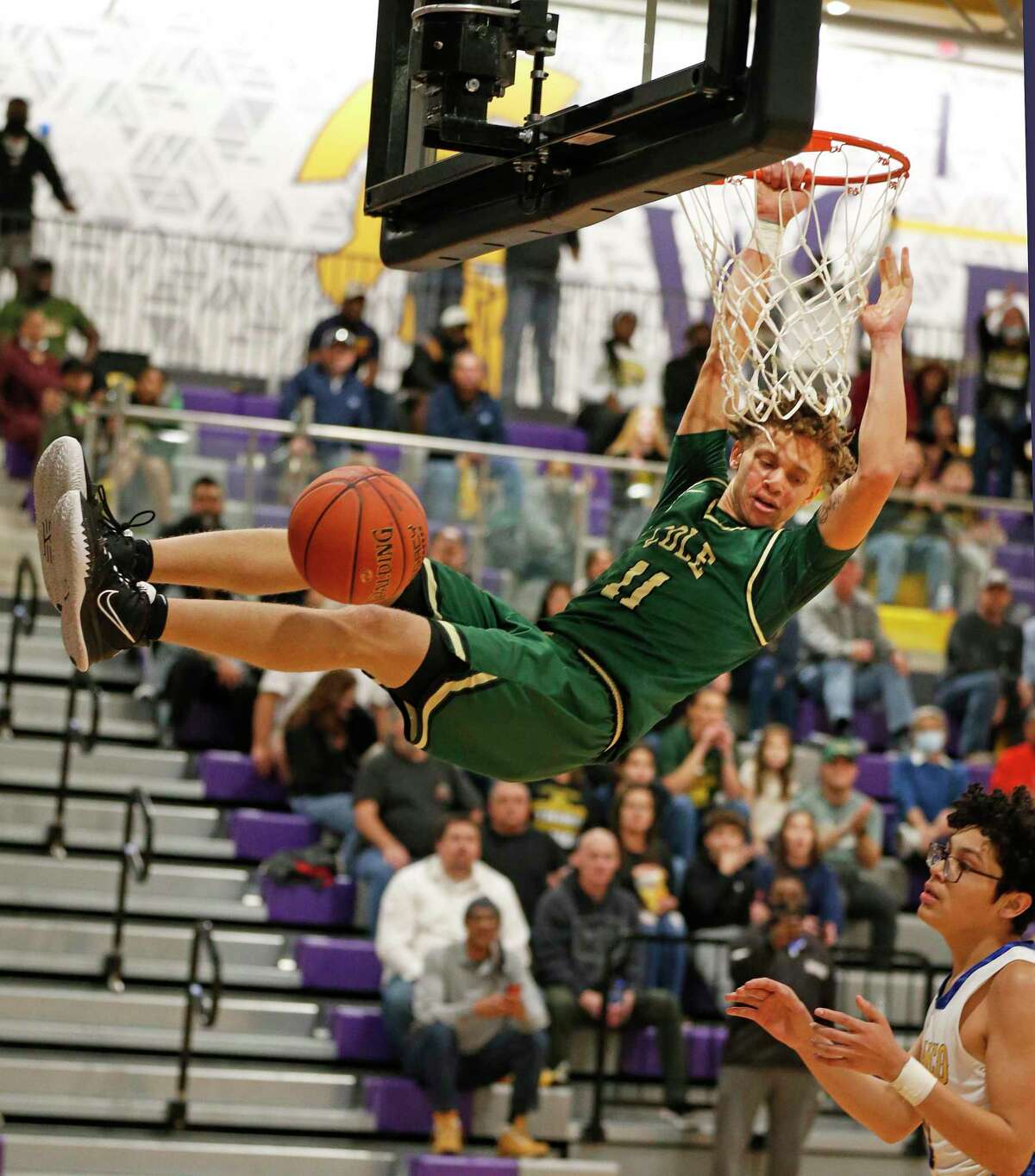 Cole guard Trey Blackmore (11) hangs on the rim after a steal and dunk in Class 3A Third round boys basketball playoff. Cole defeated Blanco 78-41 on Tuesday, March 1, 2022 at Pieper High School gym.