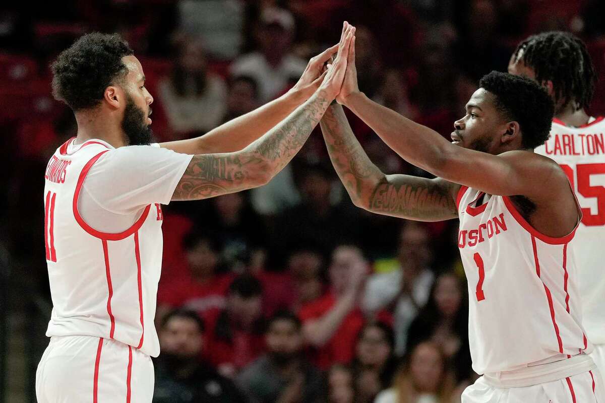 Houston guard Kyler Edwards, left, high-fives guard Jamal Shead after making a three point basket during the second half of an NCAA college basketball game against Cincinnati, Tuesday, March 1, 2022, in Houston.