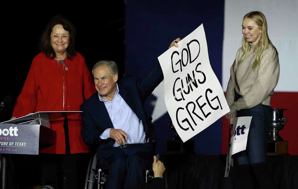 Texas Gov. Greg Abbott holds up a sign while greeting supporters with his wife Cecilia and his daughter Audrey during his watch party at the Texas State Aquarium in Corpus Christi on Tuesday, Mar. 1, 2022.