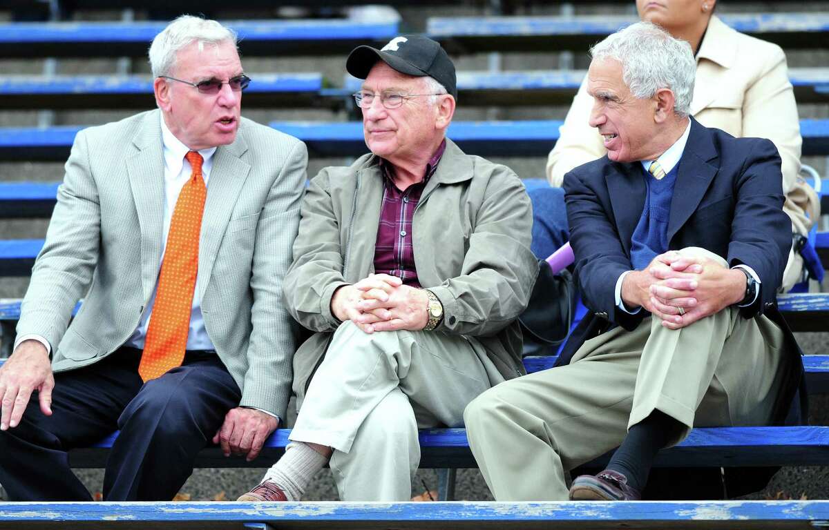 George DeLeone (left), pictured here with then-UConn coach Paul Pasqualoni (right) watching a Hillhouse football game against Xavier in New Haven in 2012, died Tuesday. He was 73.