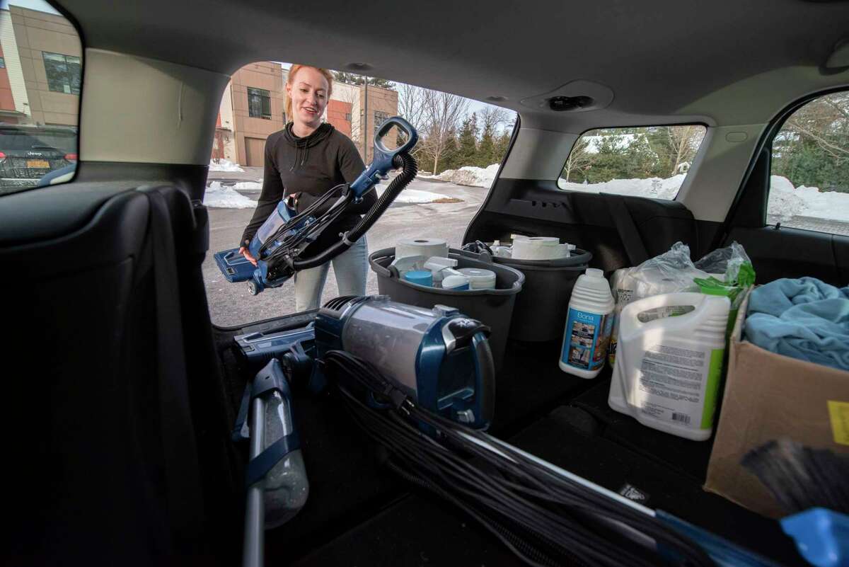 Jillian Fecteau loads a vacuum in the back of her car where she keeps her tools for her business Jillian’s Housekeeping on Monday, Feb. 28, 2022 in Saratoga Springs, N.Y.