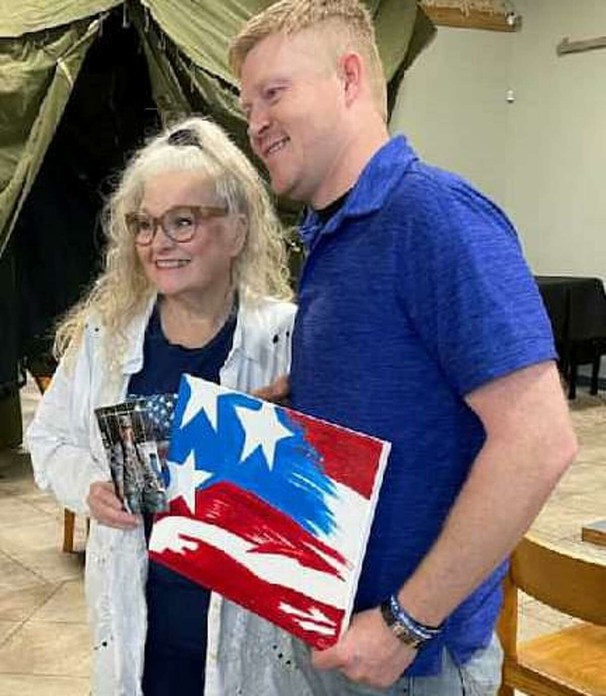 Dody Denman, left, started painting later in life and recently presented a painting of an American flag to Honor Cafe in Conroe. She’s pictured with Honor Cafe manager Chris Grouse.