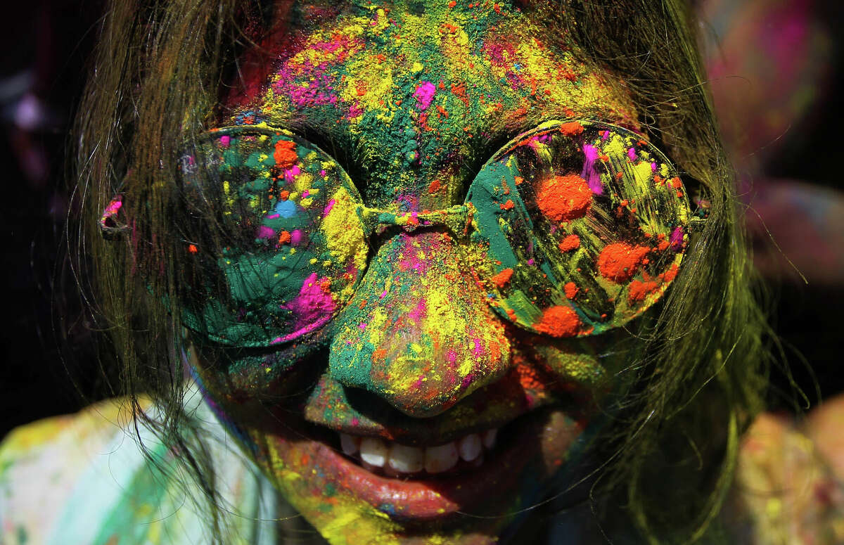 A woman, face smeared with colored powder, smiles during a religious spring festival Holi in Kuala Lumpur, Malaysia, Sunday, March 23, 2014. Holi, the Hindu festival of colors, is celebrated by people throwing colored powder and water at each other. (AP Photo) ORG XMIT: XKL125