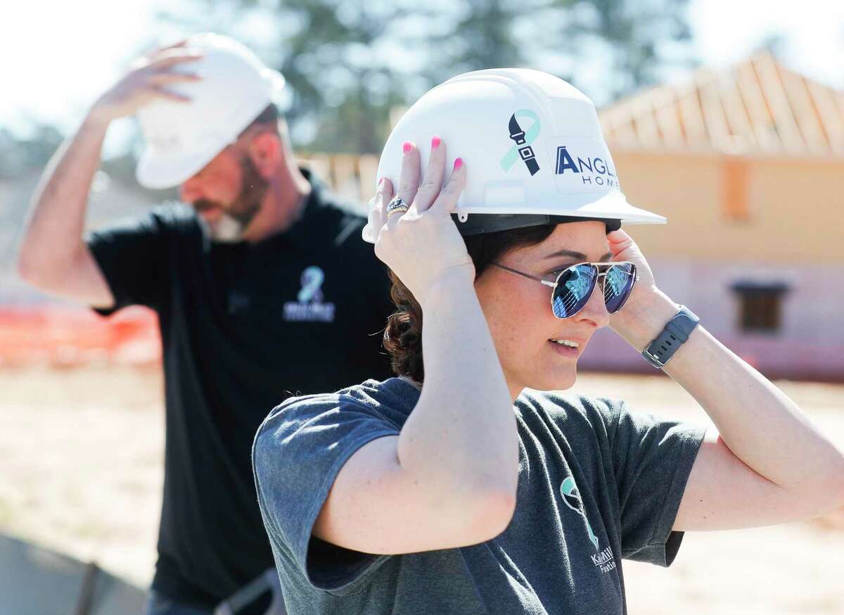 aThe Kailee Mills Foundation founder Wendy Mills puts on a construction helmet in front of her husband, David, before a groundbreaking for a home, Tuesday, March 1, 2022, in Magnolia. The funds from the home sale, which will be auctioned off on the fifth anniversary of the death of Mills’ daughter, Kailee, will be used to reduce fatalities and injuries on Texas roadways. Kailee Mills died in 2017 when she took off her seatbelt to take a backseat selfie with a friends when the car they were in was involved in an accident.
