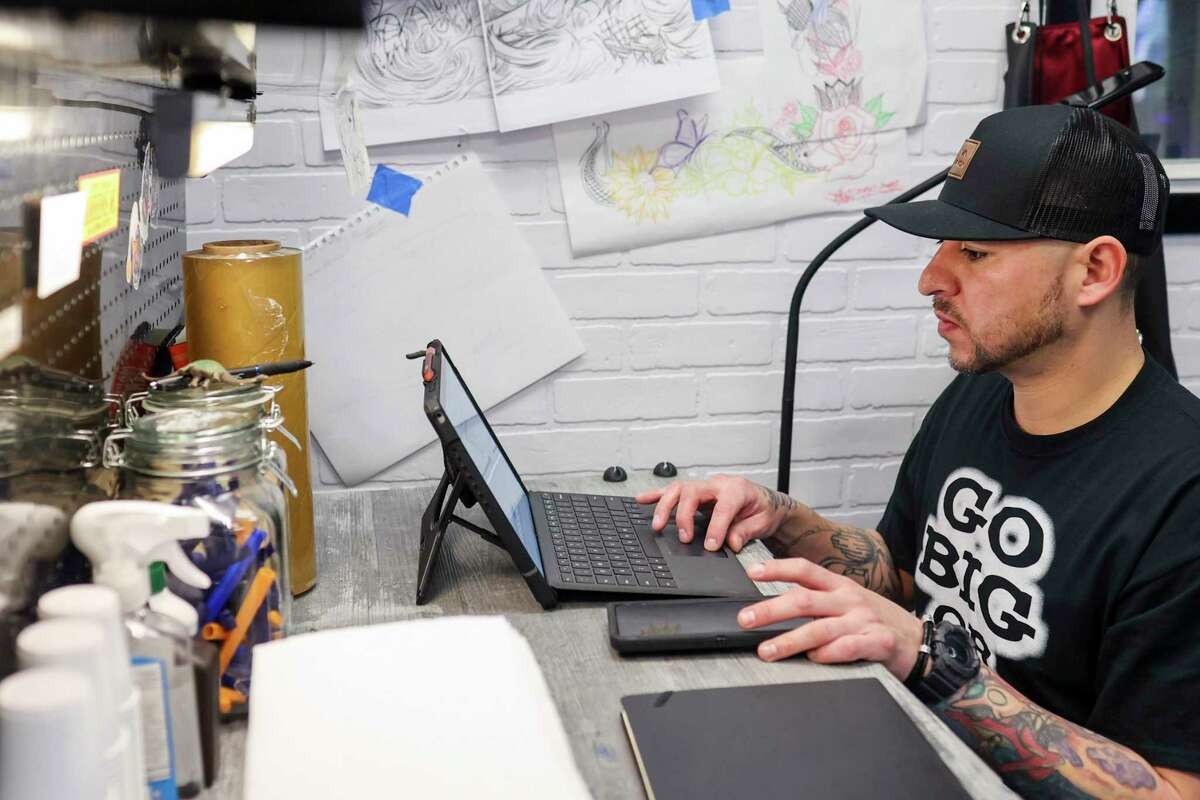 Tatoueur Richard "GROS" Lopez recherche les NFT qu'il a réalisés sur son poste de travail dans sa boutique Pleasant Dreams Co. à San Antonio, Texas, le 17 février 2022. Lopez est l'un des tatoueurs de San Antonio qui lancent des plateformes NFT pour vendre leur art comme jetons numériques.