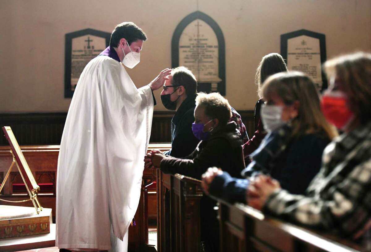 New priest in charge, the Rev. Andrew Kryzak, places ashes to the foreheads of congregants during the Ash Wednesday Mass at St. John’s Episcopal Church in Stamford. Wednesday was Kryzak’s first Mass at St. John’s. From 2016-20, he served Christ Church in Greenwich successively as seminarian, curate, and associate rector for worship, outreach and membership, but comes most recently from Washington D.C. where he serves as the associate rector of Christ Church in Georgetown.