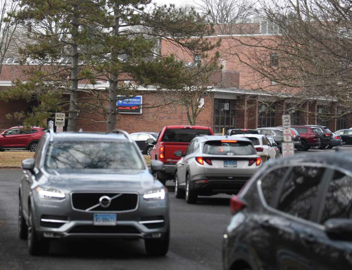 Parents drop their kids off for school at Springdale Elementary School in Stamford, Conn. Wednesday, March 2, 2022.