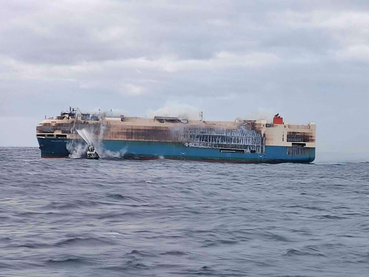 On Feb. 18, 2022, smoke billows from the burning Felicity Ace car transport ship as seen from the Portuguese Navy NPR Setubal ship southeast of the mid-Atlantic Portuguese Azores Islands. A large cargo vessel carrying cars from Germany to the United States has sunk in the mid-Atlantic, 13 days after a fire broke out on board. The ship’s manager and the Portuguese navy said the Felicity Ace sank Tuesday, March 1 about 250 miles off Portugal’s Azores Islands as it was being towed.