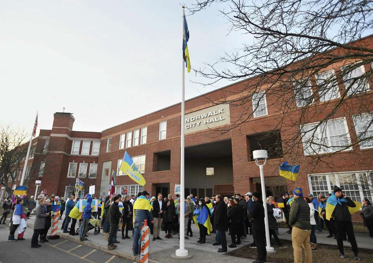 The Ukrainian flag is raised outside Norwalk City Hall as area Ukranians gather for a rally and prayer vigil in Norwalk, Conn. on Wednesday, March 2, 2022.