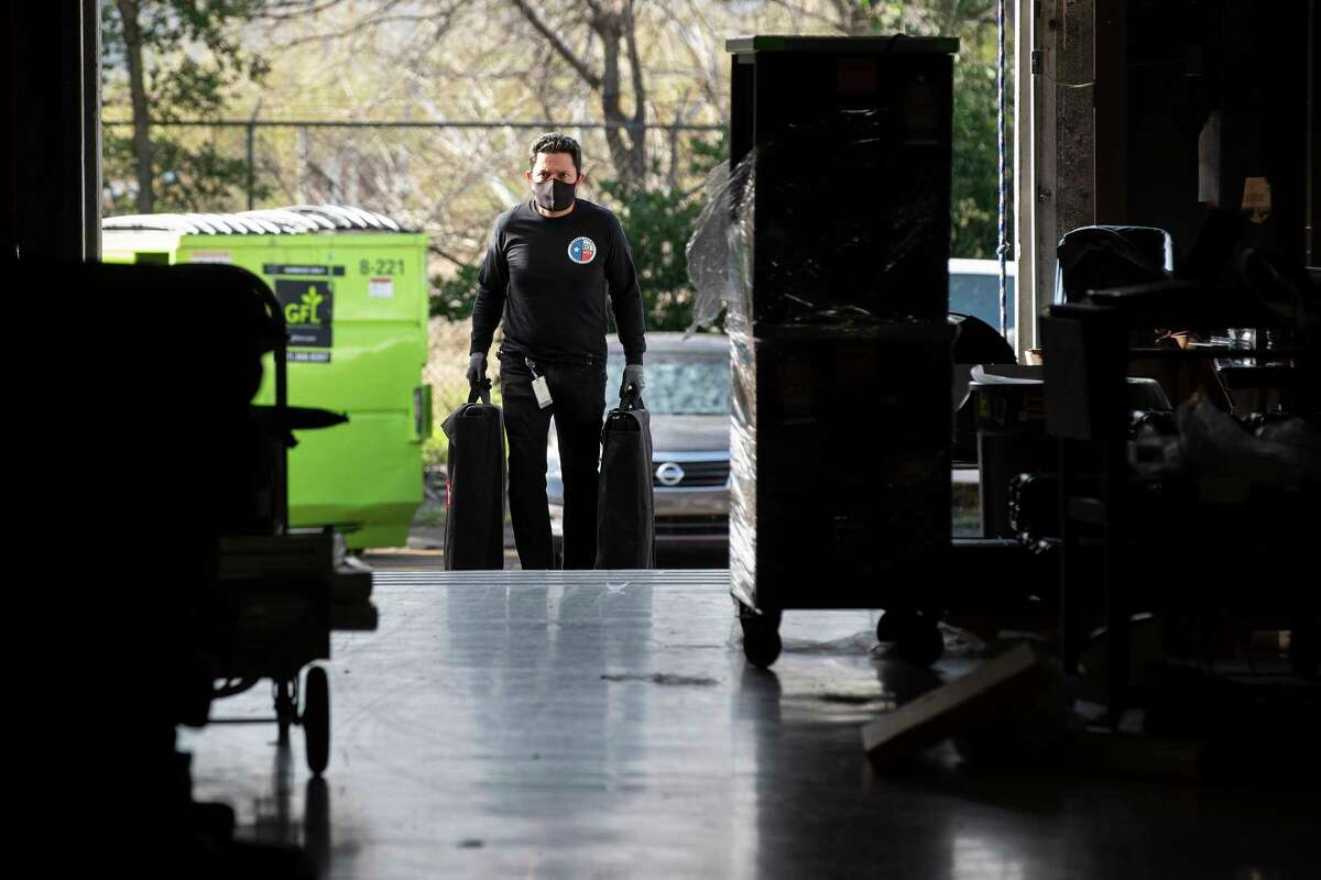 A Harris County election staffer carries in voting machines after they came in to the Harris County Election Technology Center Wednesday, March 2, 2022 in Houston.