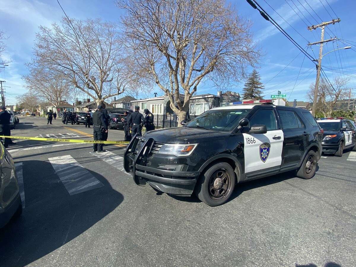 Oakland police officials are seen at the scene of a vehicle fire where one person died after driving away from police on punctured tires n a reportedly stolen van on punctured tires after officers deployed a deflation device on Wednesday morning.