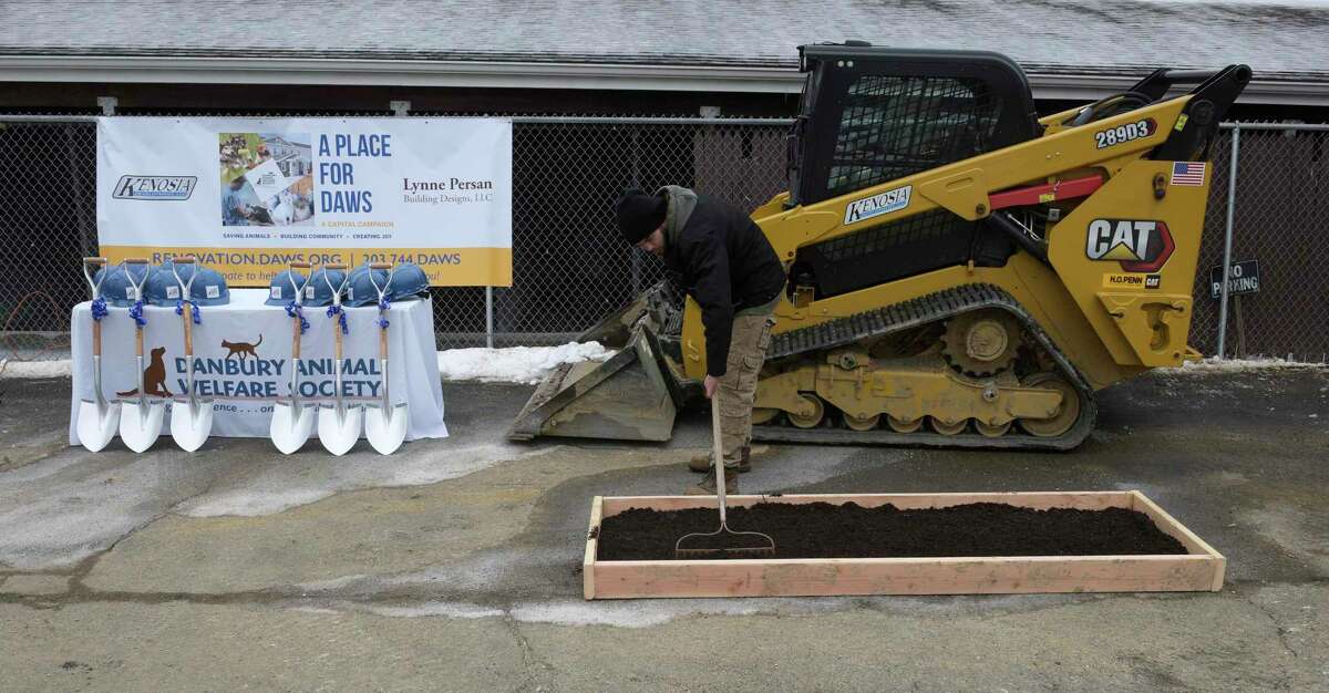 Christian Blanche, from the kennel staff of the Danbury Animal Welfare Society (DAWS), rakes out fresh dirt for the ground breaking for the renovations to DAWS facility in Bethel, Conn. March 1, 2022.