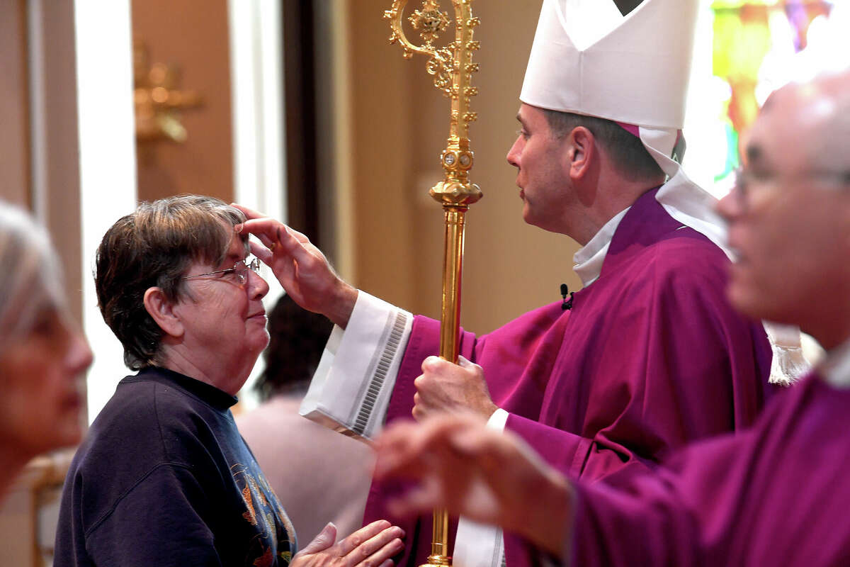 Bishop David Toups distributes ashes to those gathered at the mid-day Ash Wednesday Mass at St. Anthony Cathedral Basilica. The service kicks off the 40 days of abstinance and solemnity leading up to Easter. Photo made Wednesday, March 2, 2022 Kim Brent/The Enterprise