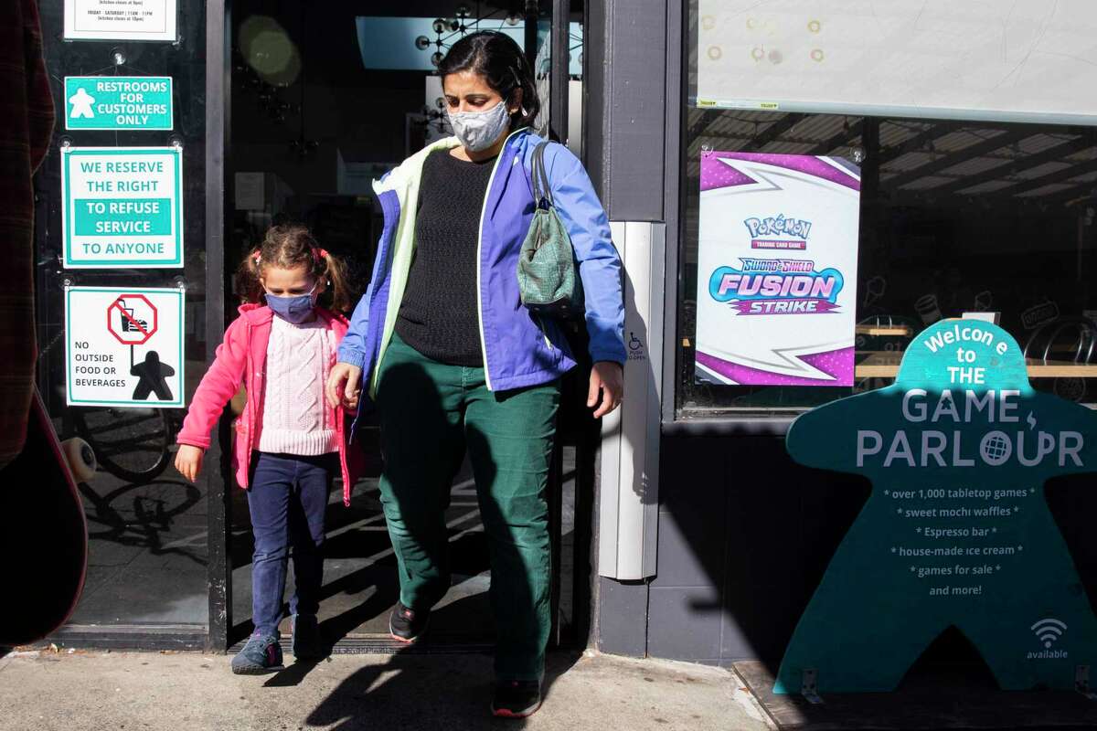 Dr. Rita Hamad and her 5-year-old daughter wear masks after ordering a waffle to share at Game Parlour in San Francisco, Calif. Tuesday, Feb. 1, 2022. Hamad wants to see her 5-year old in school without a mask.