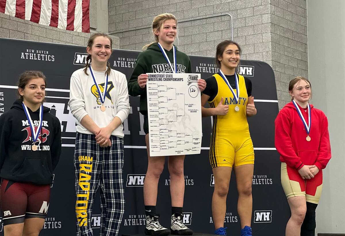 Norwalk’s Rylee Donahue (center) stands on the podium after winning the 126-pound championship at the CIAC girls wrestling tournament at the Floyd Little Athletic Center in New Haven on Sunday, Feb. 27, 2022.