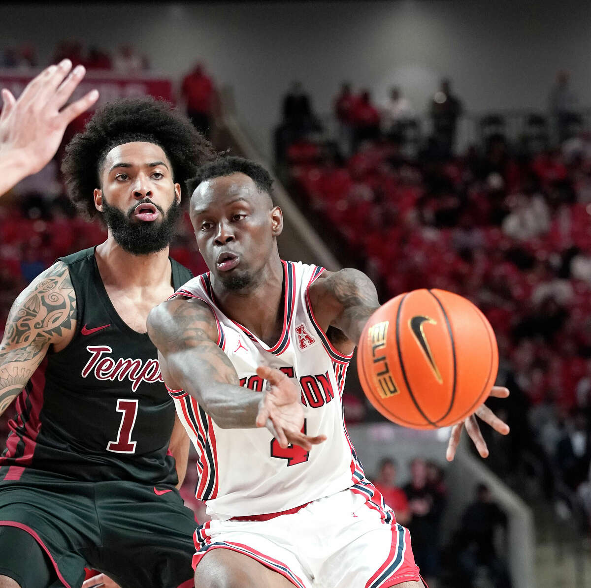 Houston Cougars guard Taze Moore (4) passes the ball against Temple Owls guard Damian Dunn (1) during the first half of a men's NCAA basketball game at Fertitta Center on the University of Houston campus on Thursday, March 3, 2022 in Houston.