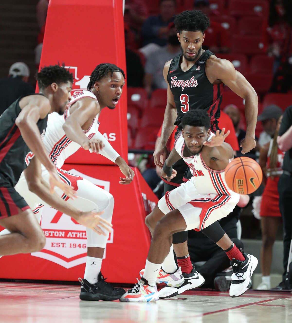 Houston Cougars guard Jamal Shead (1) reaches for a rebound against Temple Owls center Emmanuel Okpomo (21) during the first half of a men's NCAA basketball game at Fertitta Center on the University of Houston campus on Thursday, March 3, 2022 in Houston.