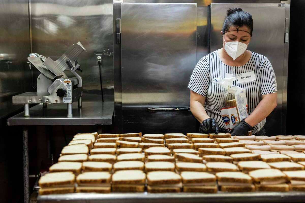 Volunteer Sara Allen assembles turkey sandwiches in the kitchen at the GLIDE Foundation in San Francisco, California Thursday, March 3, 2022.