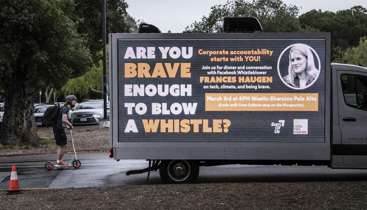A student rides by a truck advertising event with whistleblower Frances Haugen at Stanford University.