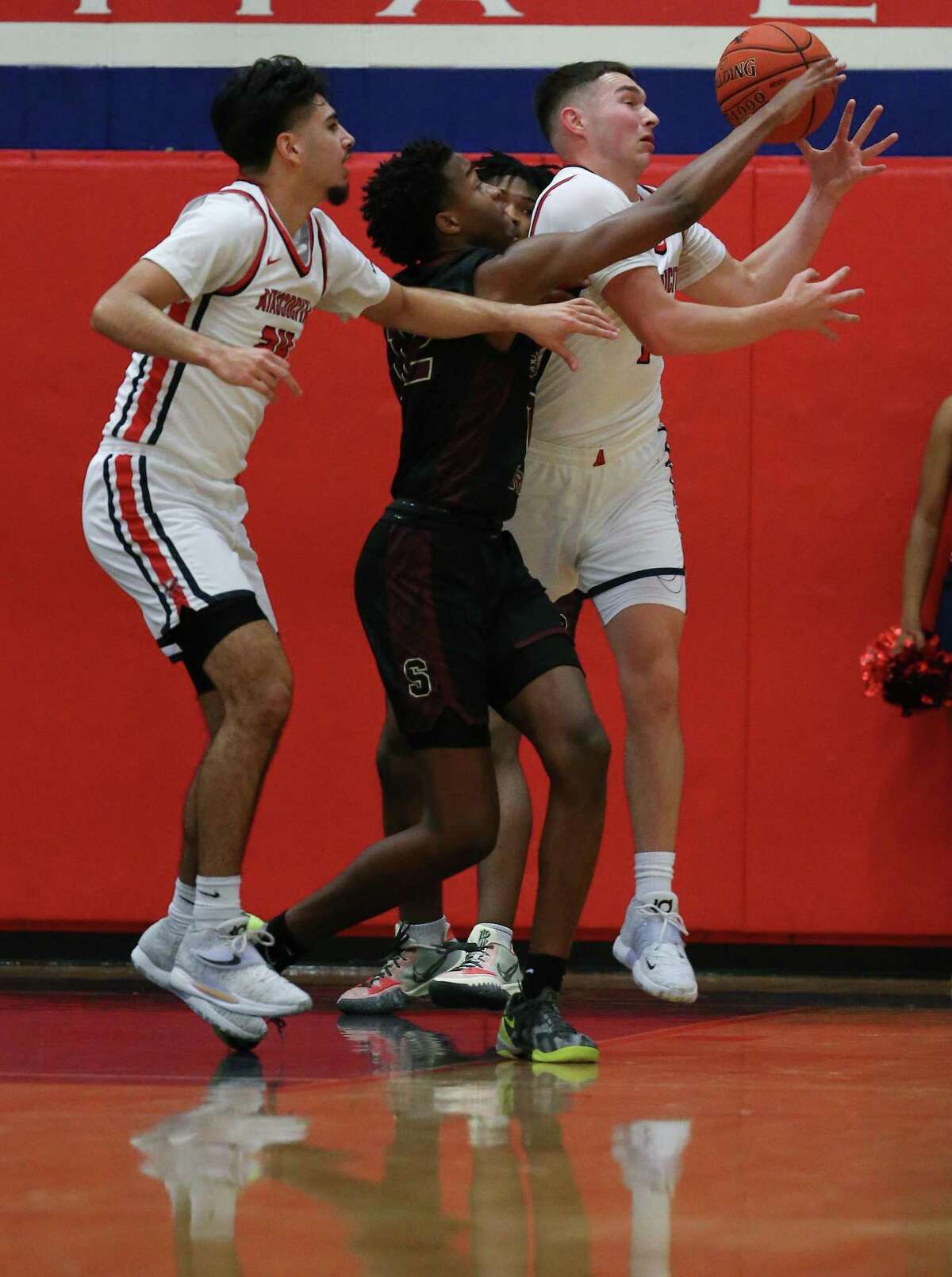 Atascocita’s David Martinez, left, and A.J. Aungst fight for a rebound with Summer Creek’s Cameron Patterson during a District 21-6A high school basketball game Friday, Dec. 17, 2021 in Humble.