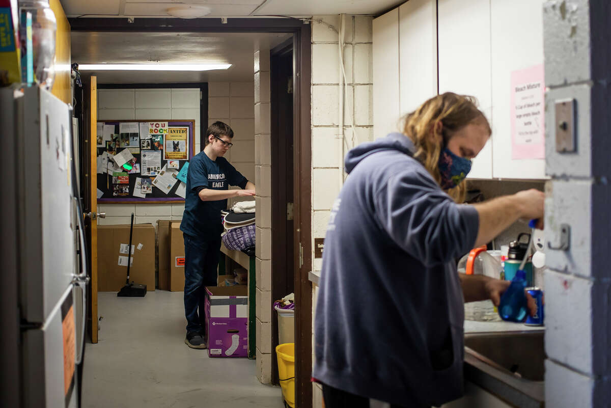 Volunteer TJ Chesney, left, folds towels during his shift at the Humane Society of Midland County alongside another employee Thursday, Feb. 24, 2022 on E. Ashman Street in Midland.