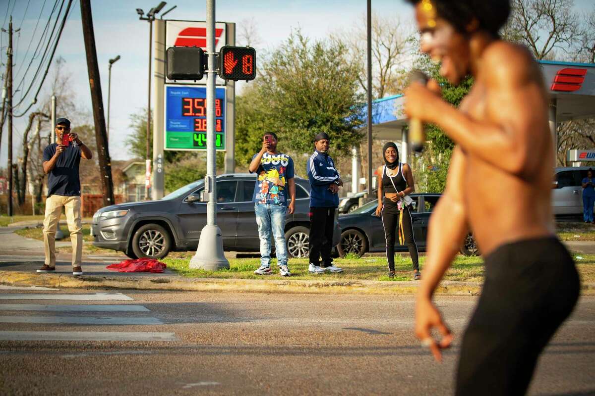 People move onto the median of Cavalcade Street to watch Dimitri Reeves perform, Thursday, March 3, 2022, in Houston. He can be found at intersections around Houston doing his act.