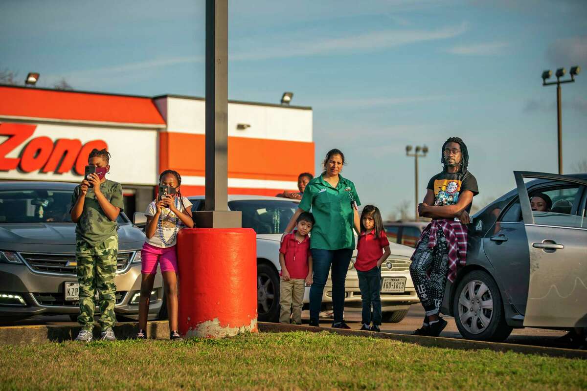 People pull over and watch from the parking lot of an AutoZone as Dimitri Reeves performs at the corner of Lockwood Drive and Calvalcade Street, Thursday, March 3, 2022, in Houston. 