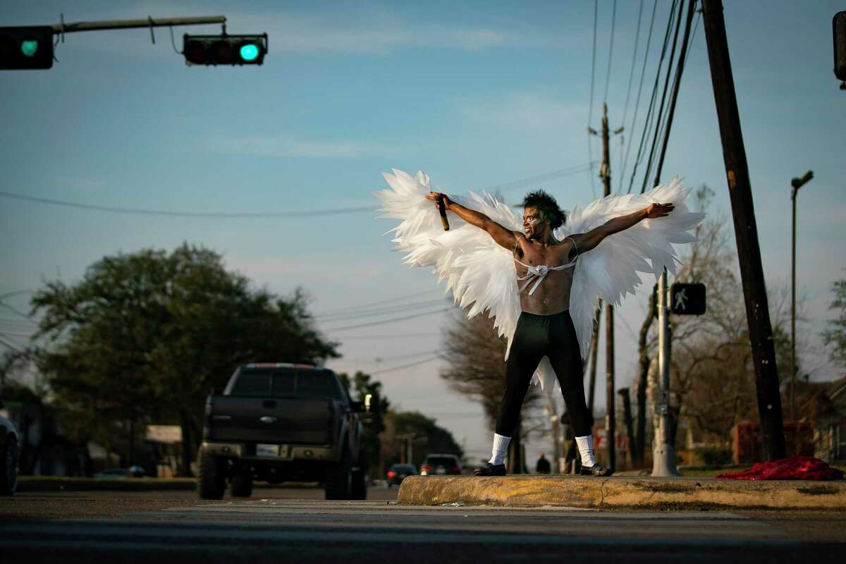 Wearing his wings, Dimitri Reeves takes to the median of Calvalcade Street to perform, Thursday, March 3, 2022, in Houston. Between songs, Reeves urges viewers to love one another, and says his goal is to spread positivity and love in the world. 